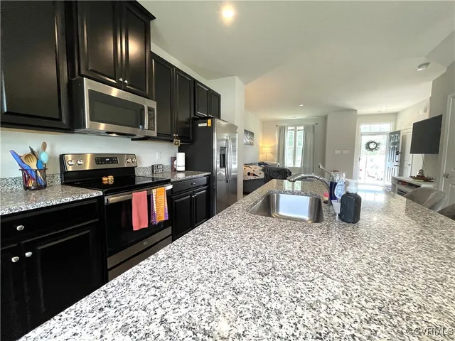 a kitchen with stainless steel appliances granite countertop a sink dishwasher stove top oven and cabinets