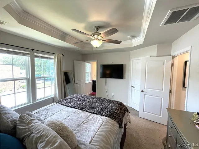 a bedroom with a large bed a flat tv screen and a large window