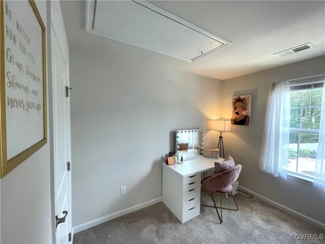 a view of a workspace with furniture and a window