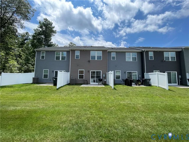 a front view of house with yard and trees in the background