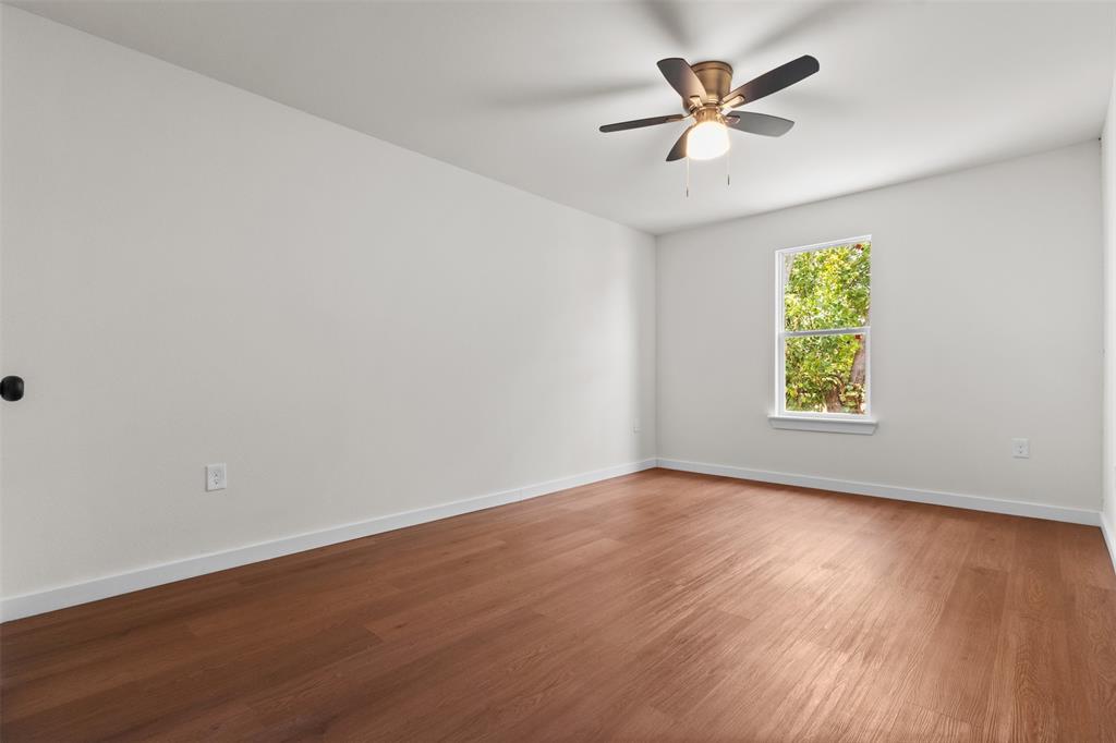513 East Union Bower Road Irving, TX 75061 - Photo 23 of 34 Spacious room featuring wood-finish flooring, a ceiling fan with integrated lighting, and a window providing natural illumination