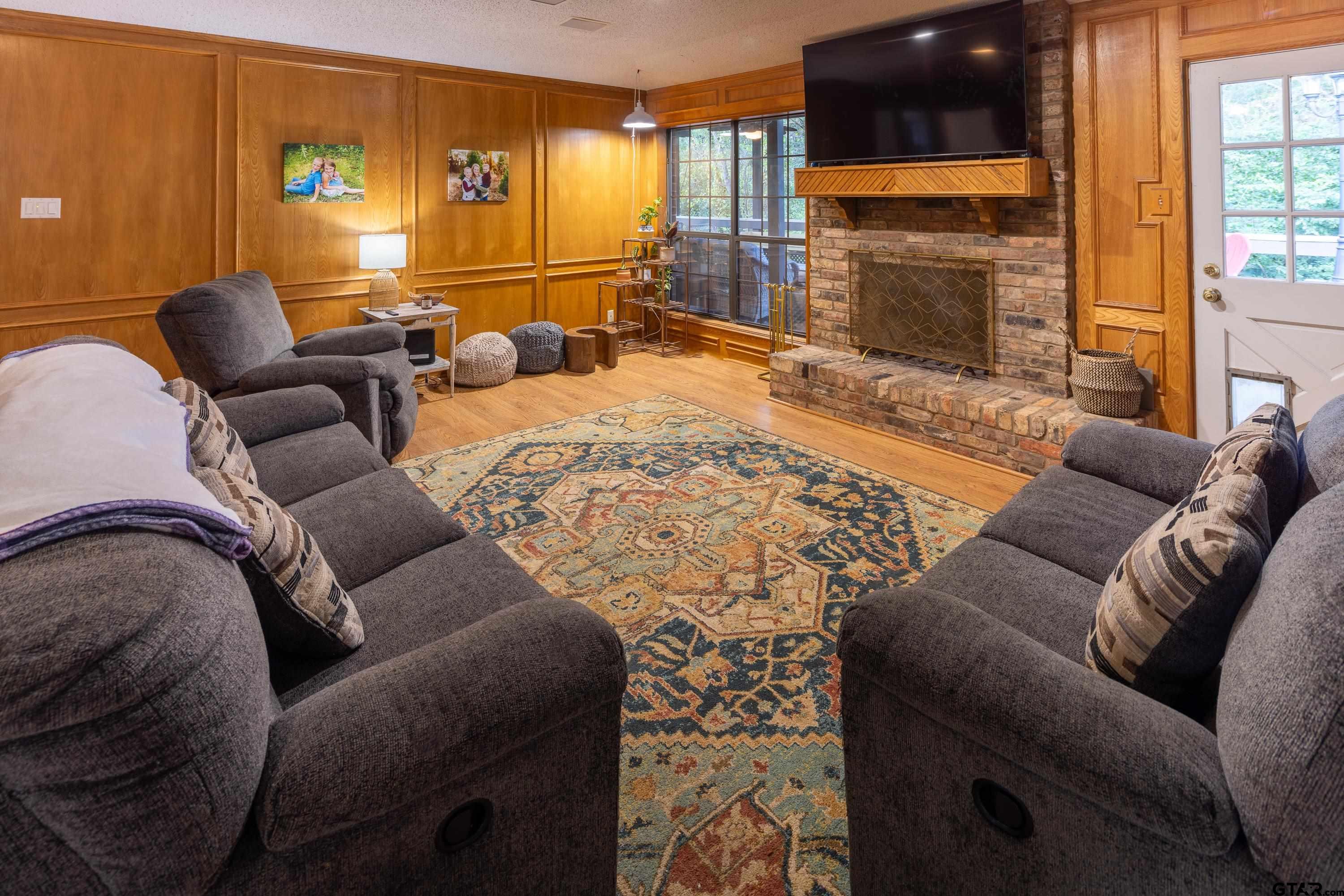2900 West Azalea Drive Tyler, TX 75701 - Photo 13 of 37 a living room with furniture a fireplace and a flat screen tv