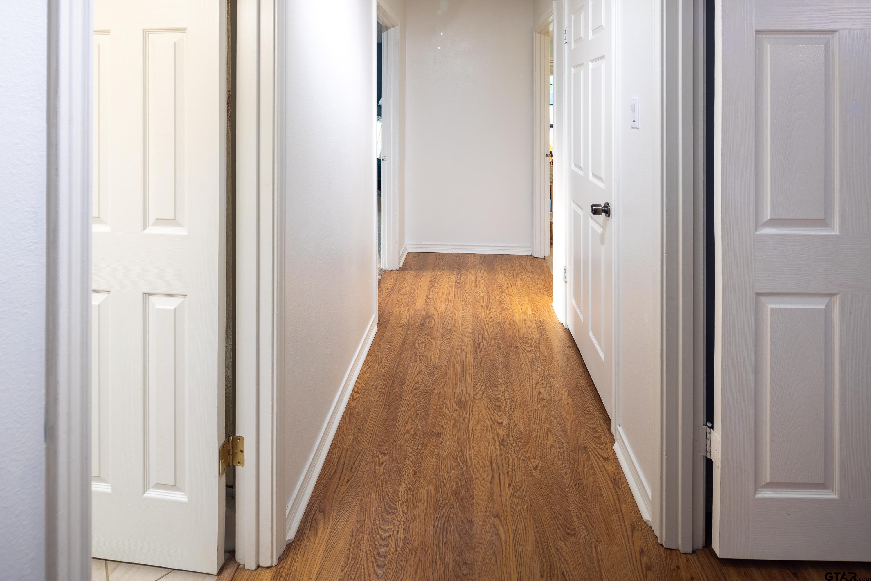 2900 West Azalea Drive Tyler, TX 75701 - Photo 16 of 37 a view of a hallway with wooden floor and staircase