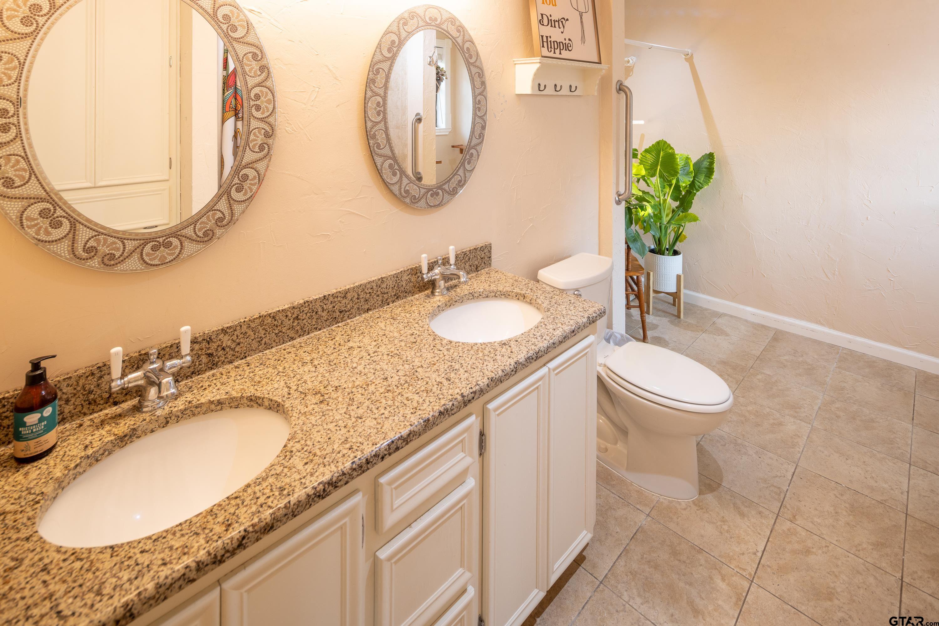 2900 West Azalea Drive Tyler, TX 75701 - Photo 19 of 37 a bathroom with a granite countertop sink and a mirror