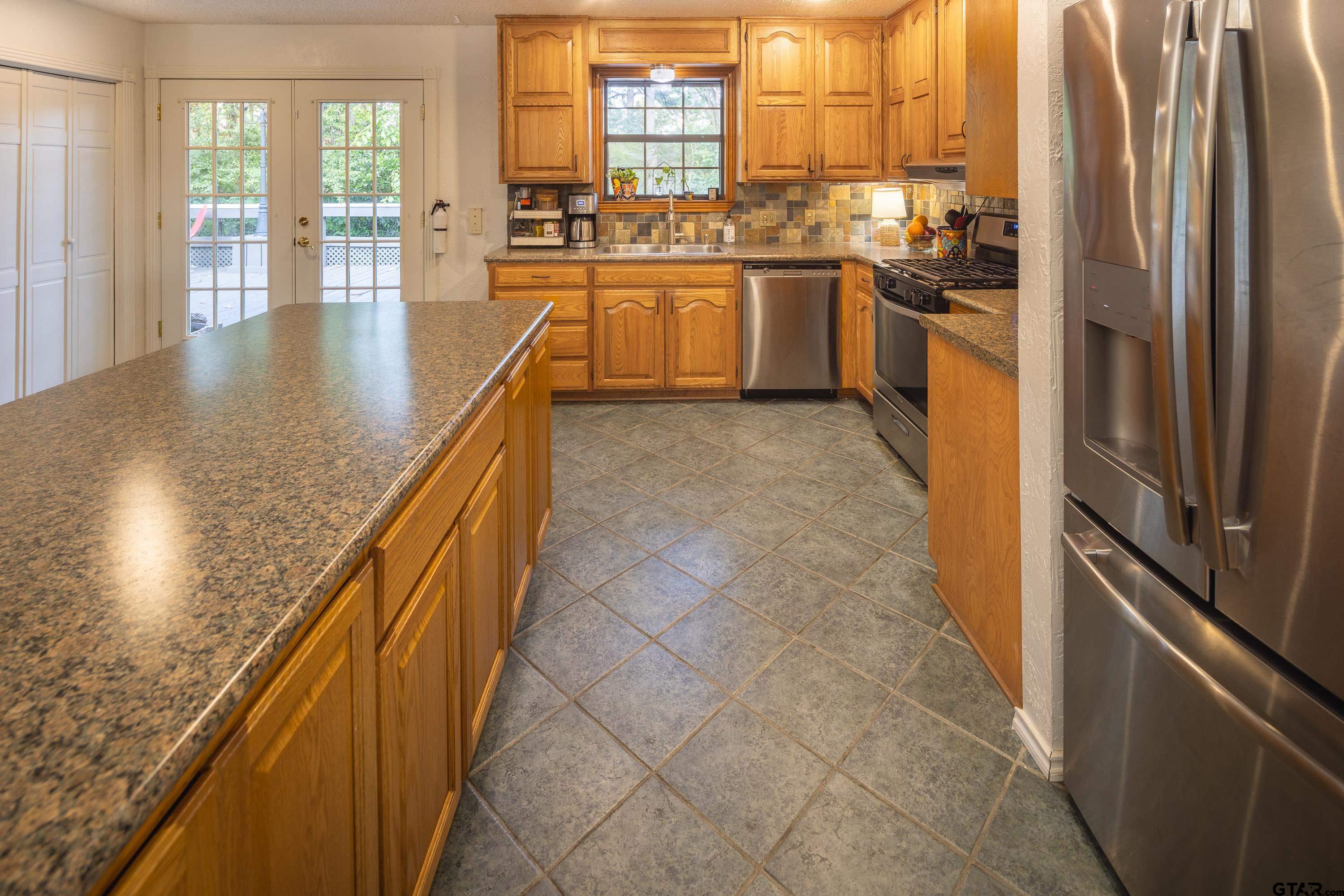 2900 West Azalea Drive Tyler, TX 75701 - Photo 7 of 37 a kitchen with stainless steel appliances granite countertop a refrigerator a stove and a sink