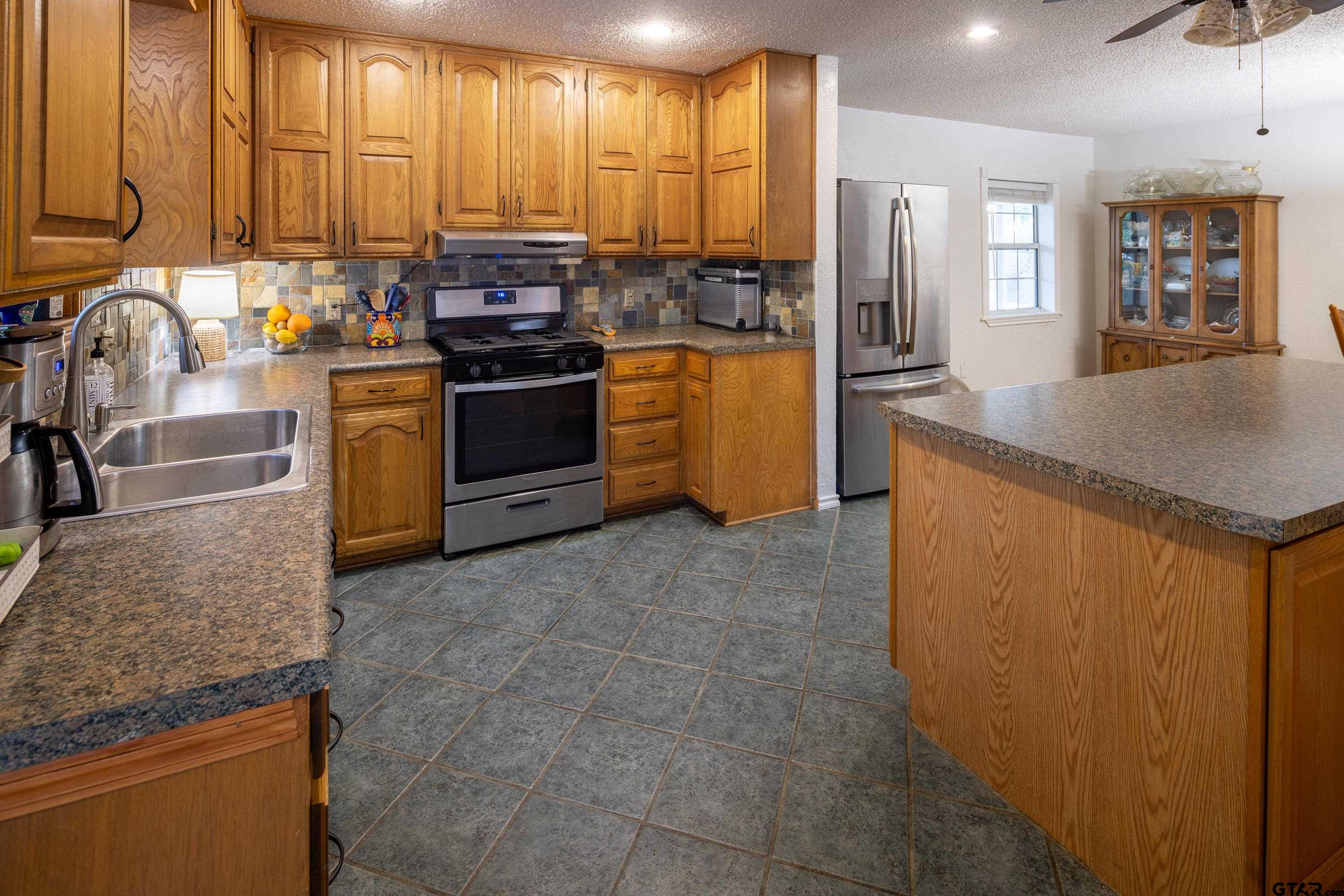 2900 West Azalea Drive Tyler, TX 75701 - Photo 8 of 37 a kitchen with stainless steel appliances granite countertop a stove a sink and a refrigerator