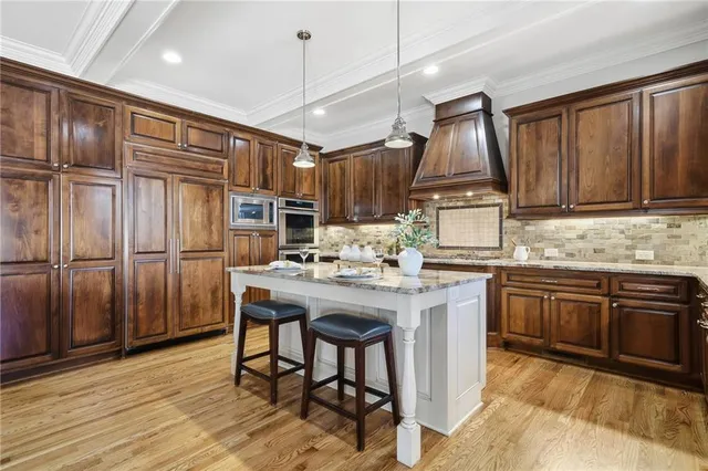 a kitchen with kitchen island granite countertop wooden floors and stainless steel appliances