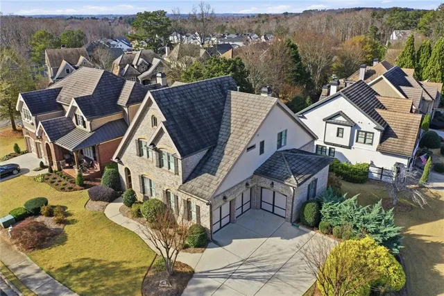 a view of a white house with large windows and a yard