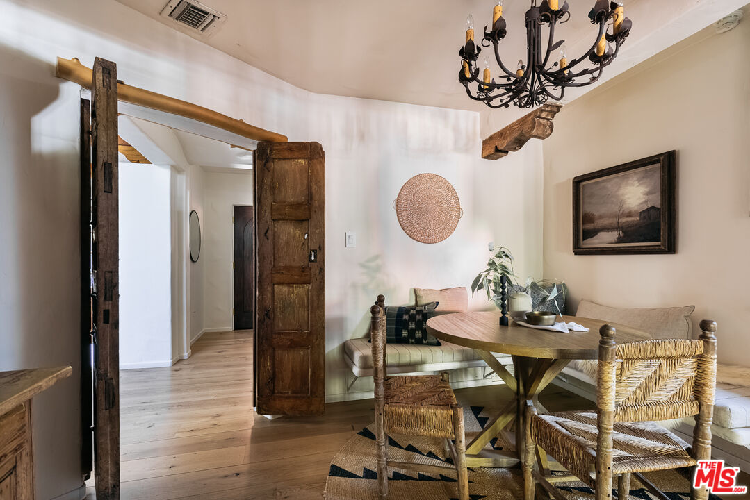 4342 Bakman Avenue Studio City, CA 91602 - Photo 7 of 31 a living room with a dining table wooden floor and a chandelier
