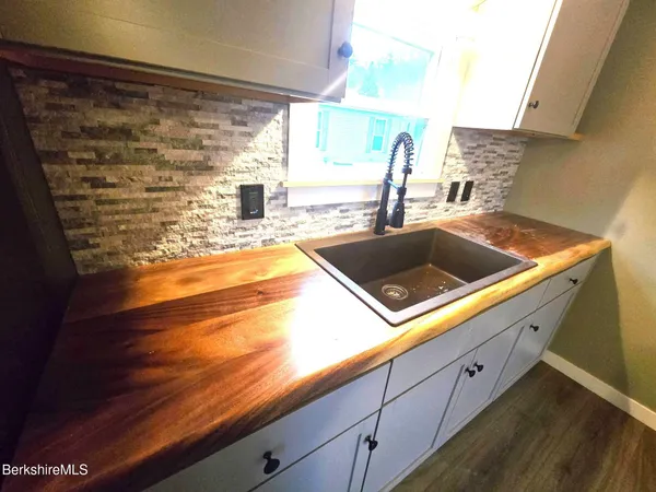 a view of a kitchen with a sink and wooden floor