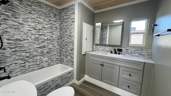 a bathroom with a granite countertop toilet sink and mirror
