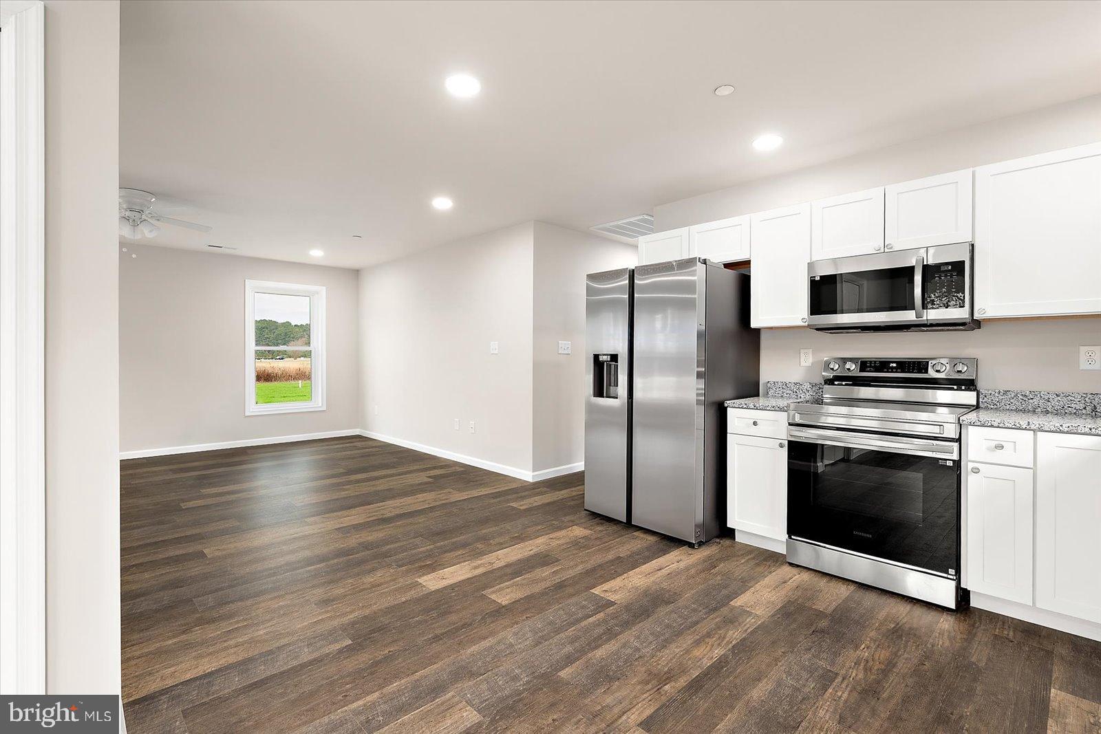 3963 Disharoon Road Eden, MD 21822 - Photo 16 of 61 a kitchen with granite countertop a refrigerator and a stove top oven