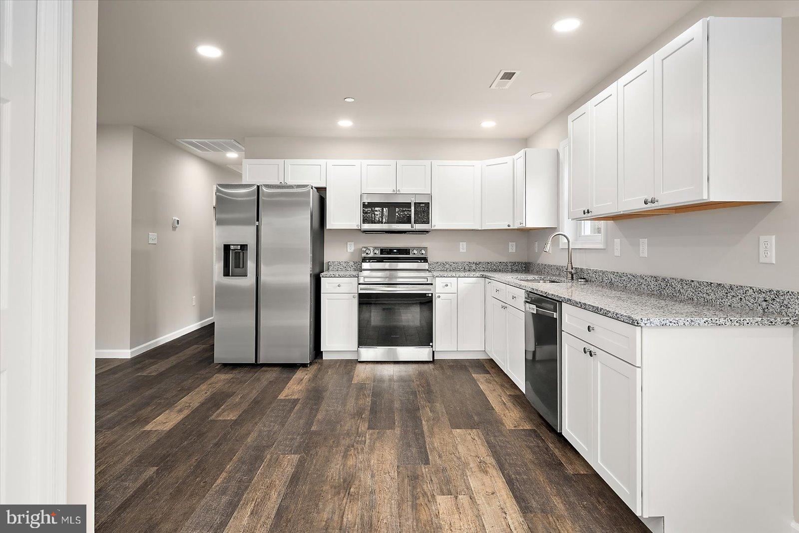 3963 Disharoon Road Eden, MD 21822 - Photo 17 of 61 a kitchen with granite countertop a refrigerator oven a sink dishwasher and a stove with wooden floor