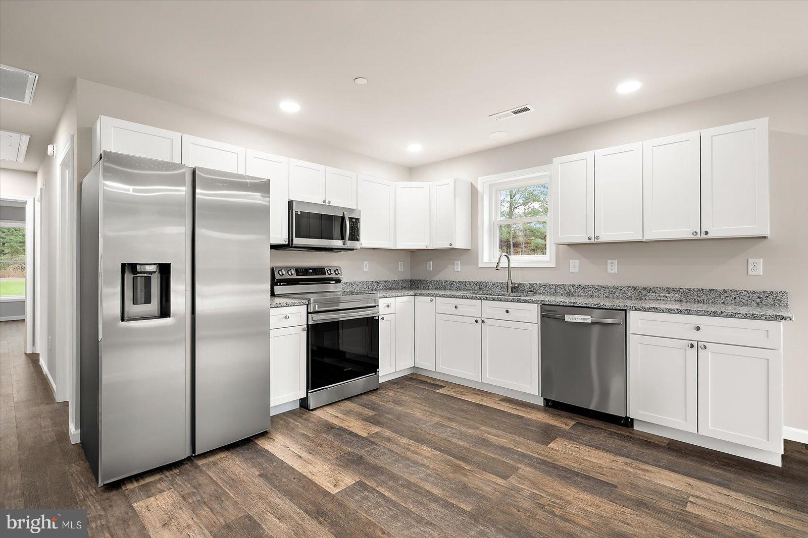 3963 Disharoon Road Eden, MD 21822 - Photo 19 of 61 a kitchen with granite countertop white cabinets stainless steel appliances and a window