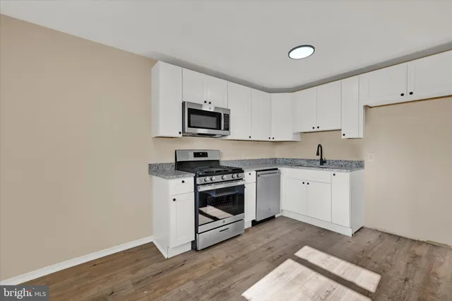 a kitchen with a stove a sink and a microwave