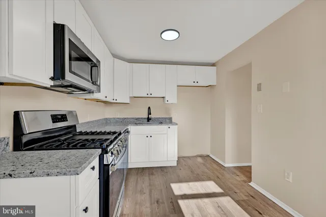 a kitchen with granite countertop a sink and a stove top oven