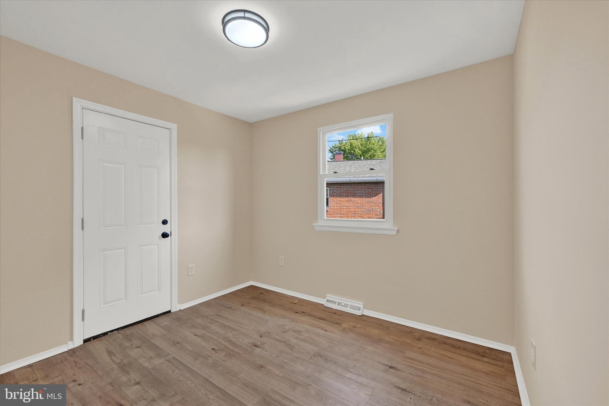 8577 Main Avenue Pasadena, MD 21122 - Photo 9 of 19 a view of an empty room with wooden floor and a window