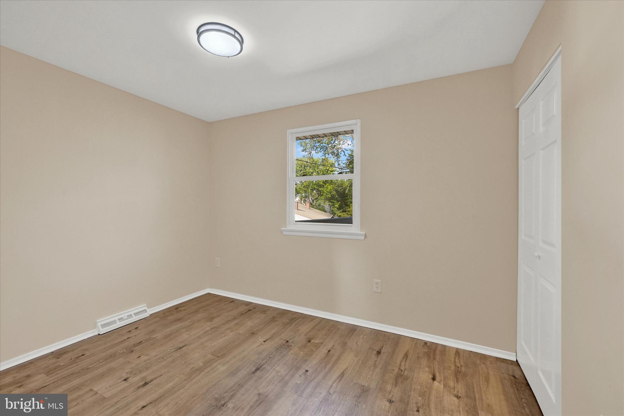 8577 Main Avenue Pasadena, MD 21122 - Photo 10 of 19 an empty room with wooden floor and windows