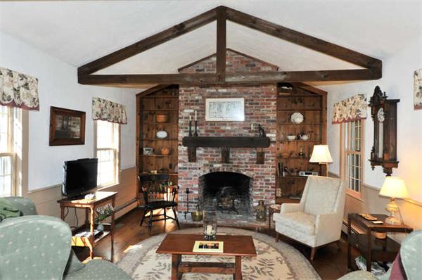 37 Sampson Road Bolton, MA 01740 - Photo 4 of 29 a living room with furniture a flat screen tv and a fireplace