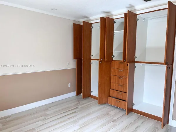 an empty room with wooden floor and closet