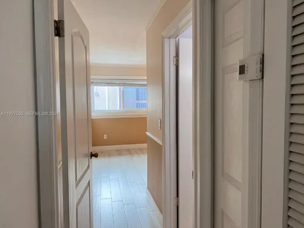a view of a hallway with wooden floor and closet