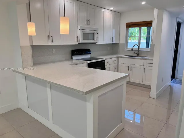 a kitchen with white cabinets and white appliances