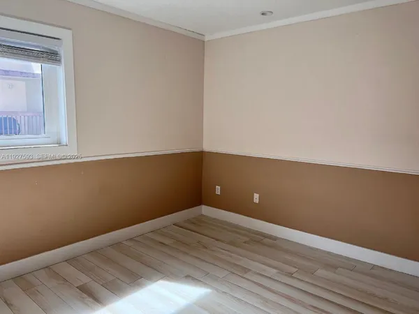 a view of a room with wooden floor and small cabinets