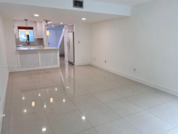 a view of a kitchen with a sink and a refrigerator