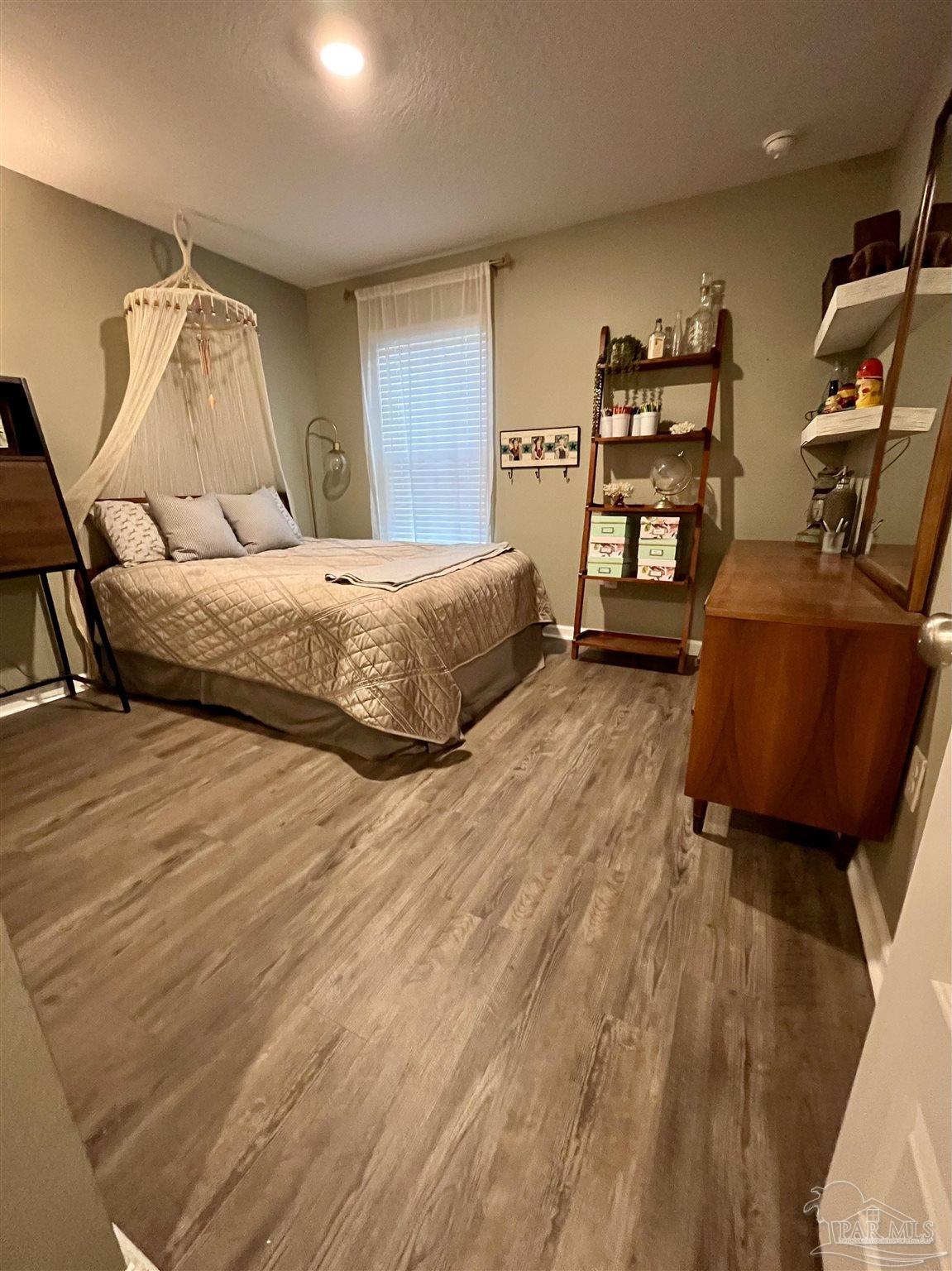 5375 Peach Drive Milton, FL 32571 - Photo 13 of 34 a bedroom with a bed and wooden floor