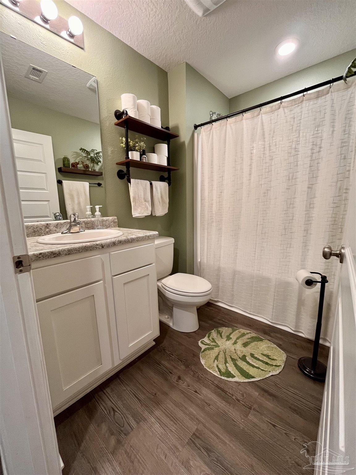 5375 Peach Drive Milton, FL 32571 - Photo 15 of 34 a bathroom with a sink a toilet a mirror and shower