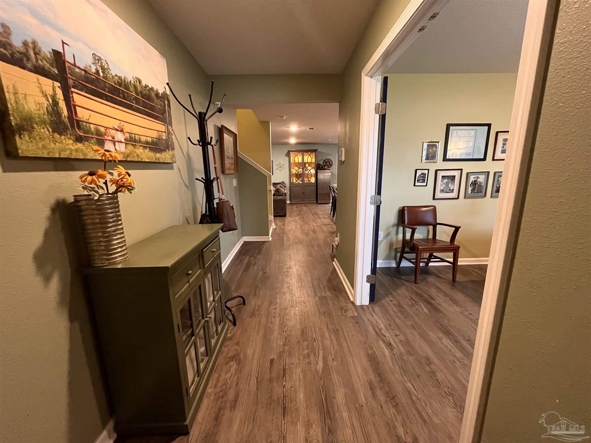 5375 Peach Drive Milton, FL 32571 - Photo 3 of 34 a view of a hallway with wooden floor and stairs