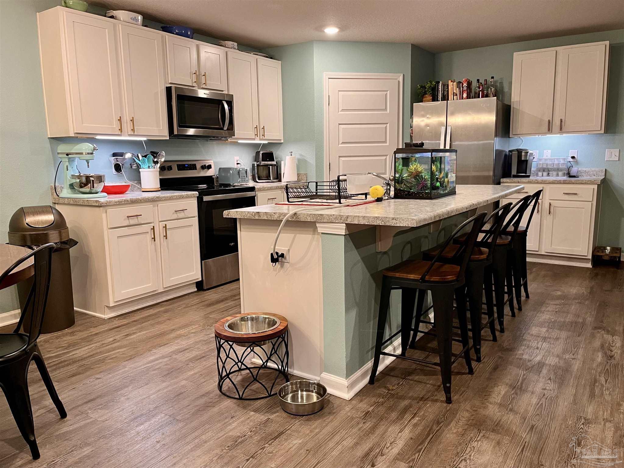 5375 Peach Drive Milton, FL 32571 - Photo 6 of 34 a kitchen with a sink a microwave a stove and refrigerator