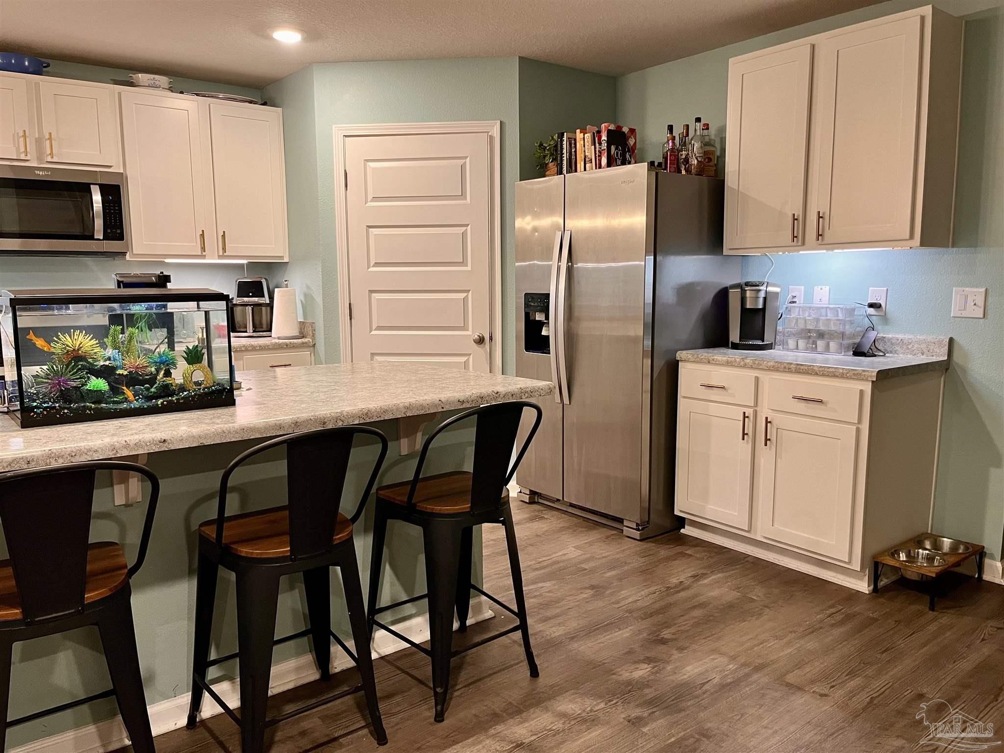 5375 Peach Drive Milton, FL 32571 - Photo 7 of 34 a kitchen with stainless steel appliances a dining table chairs refrigerator and sink