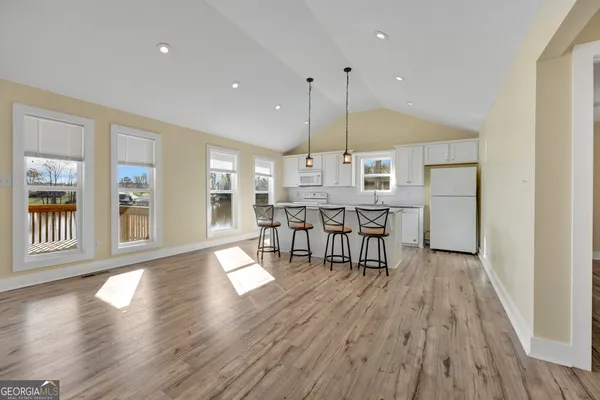 a kitchen with stainless steel appliances granite countertop a table chairs and a wooden cabinets