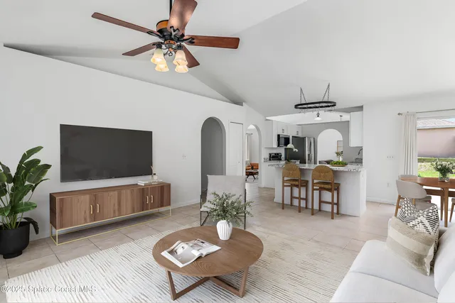 a living room with furniture a flat screen tv and a potted plant