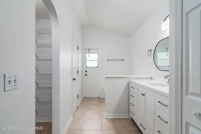 a spacious bathroom with a mirror a sink and a mirror