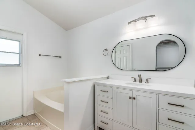 a bathroom with a sink mirror and vanity
