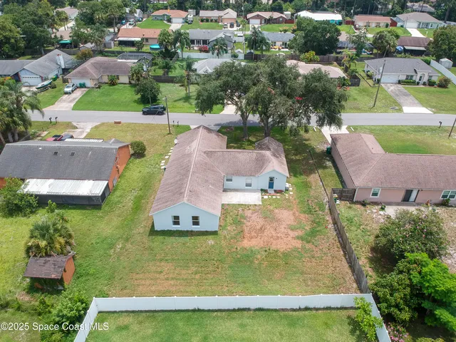 an aerial view of residential houses with outdoor space and swimming pool