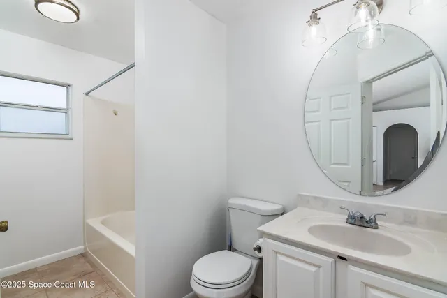 a bathroom with a sink vanity granite and toilet