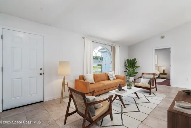 a living room with furniture and a potted plant