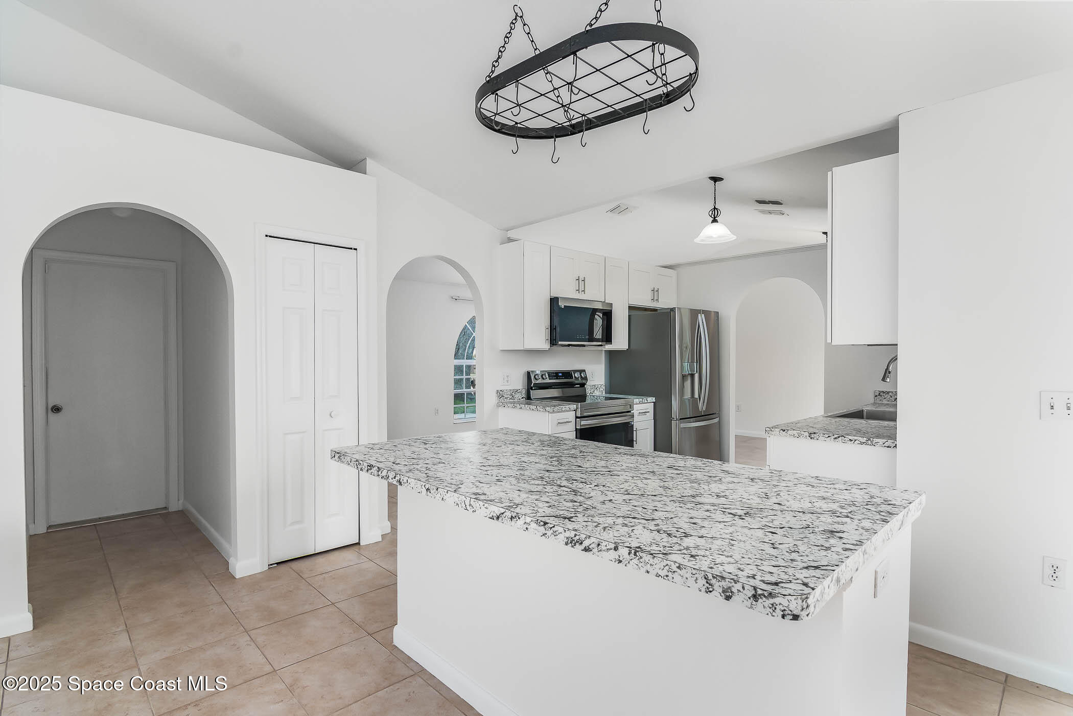 6760 Cairo Road Cocoa, FL 32927 - Photo 34 of 51 a view of a kitchen with kitchen island stainless steel appliances a sink cabinets and wooden floor