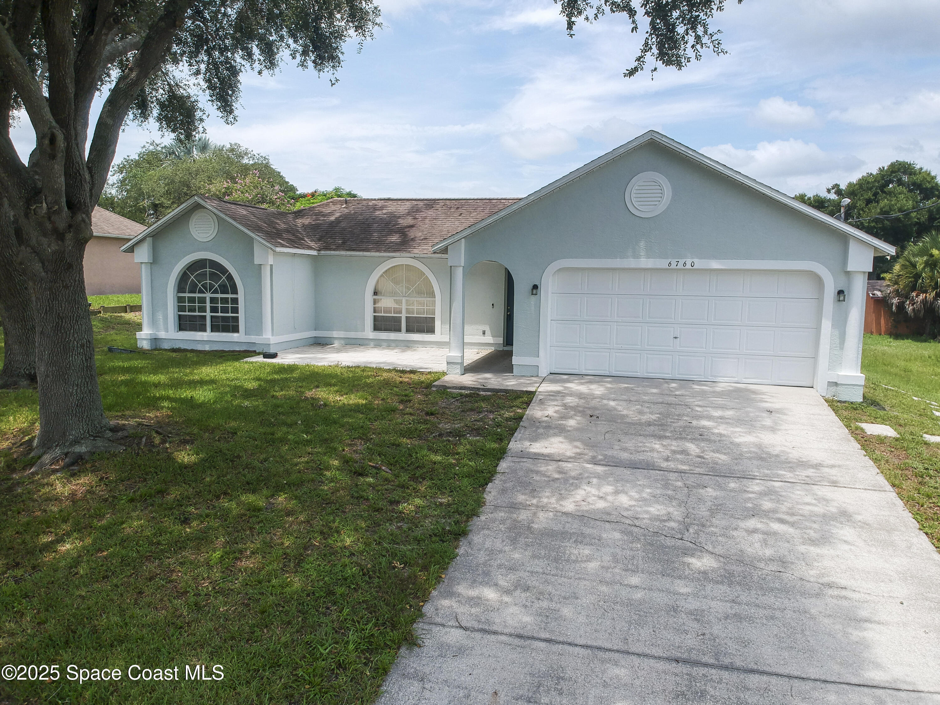 6760 Cairo Road Cocoa, FL 32927 - Photo 46 of 51 a front view of a house with a yard and garage