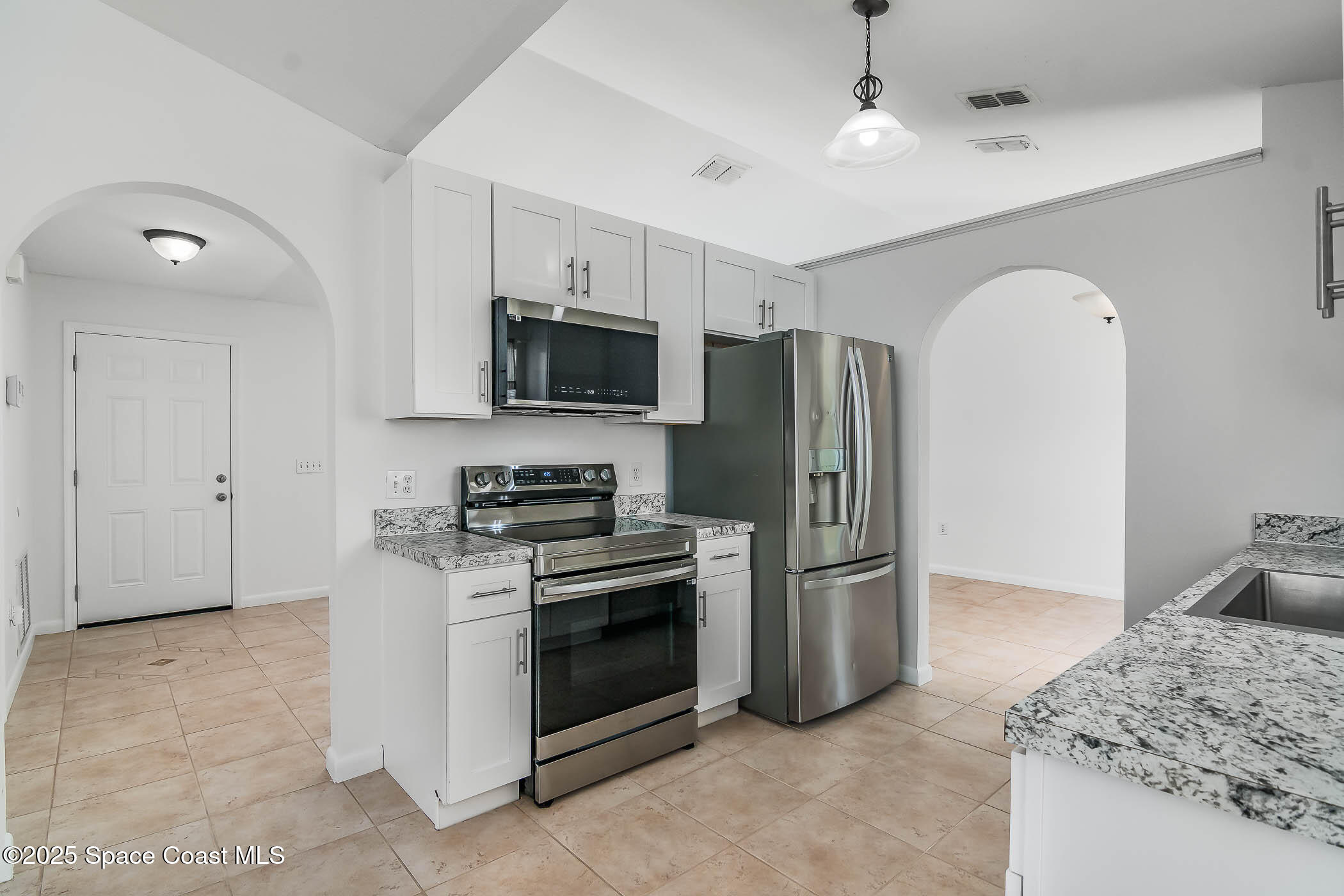 6760 Cairo Road Cocoa, FL 32927 - Photo 8 of 51 a kitchen with stainless steel appliances granite countertop a stove a refrigerator and a sink