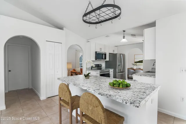 a kitchen with stainless steel appliances granite countertop a sink refrigerator and cabinets