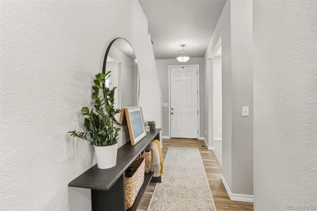 a view of a hallway with wooden floor and a potted plant