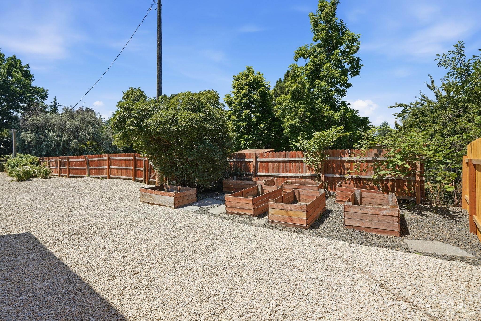 2152 Artesian Road Eagle, ID 83616 - Photo 50 of 50 Expansive gravel yard featuring a perimeter wood fence and multiple raised garden beds