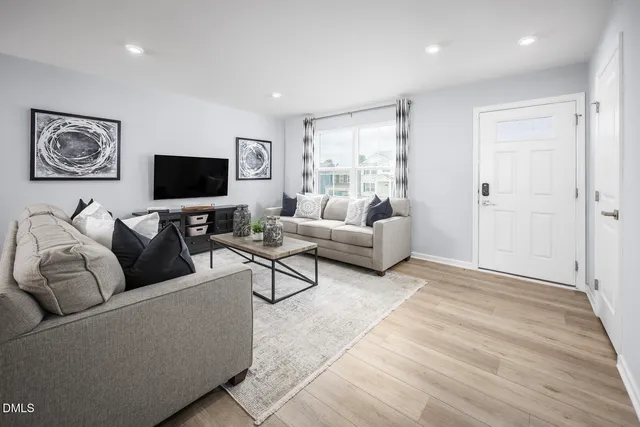 a kitchen with stainless steel appliances granite countertop a dining table chairs refrigerator and sink