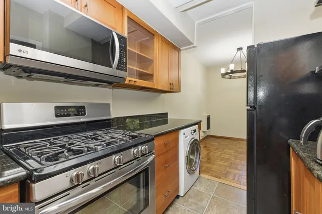 a kitchen with stainless steel appliances granite countertop a stove and a microwave
