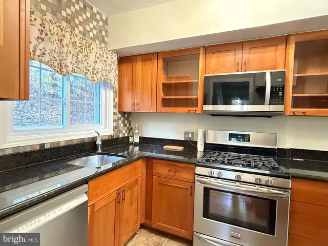a kitchen with stainless steel appliances granite countertop a stove and a microwave