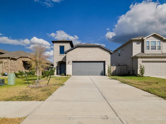 a front view of a house with a yard and garage